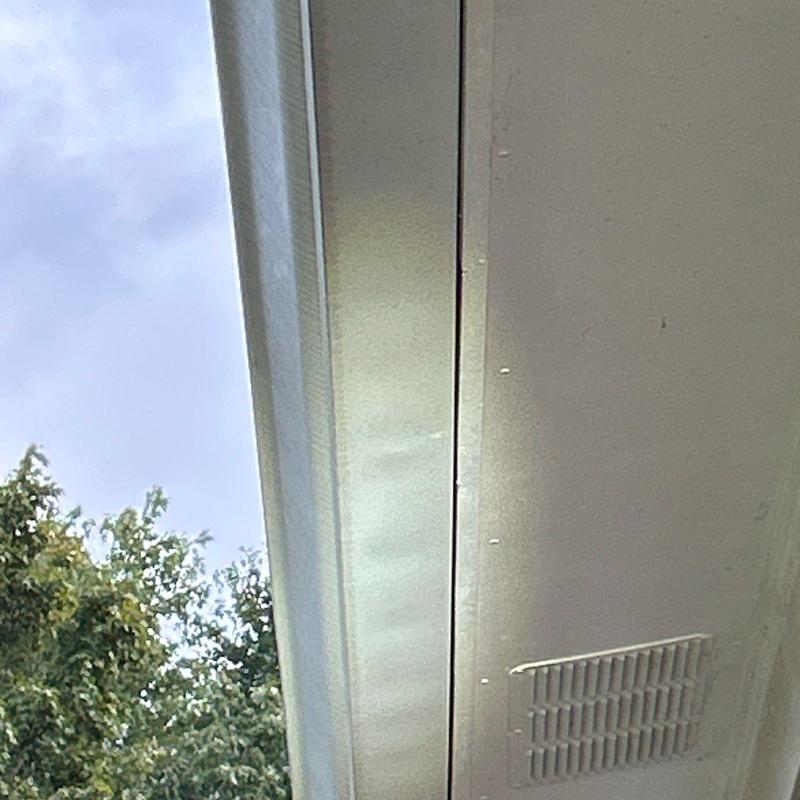 Eave soffit with ventilation grate and nearby trees