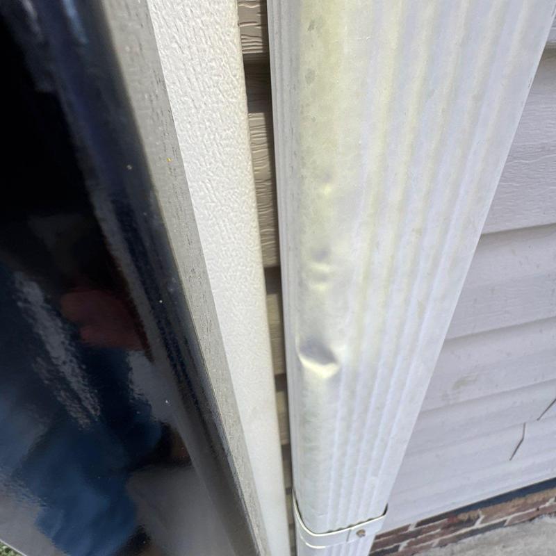 Vinyl downspout with hail damage dents