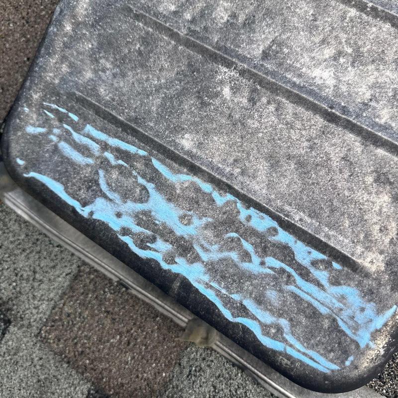 Hail-damaged roof shingle with chalk markings