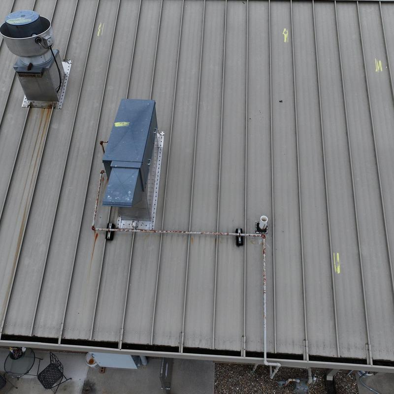 Metal commercial roof with hail damage marks