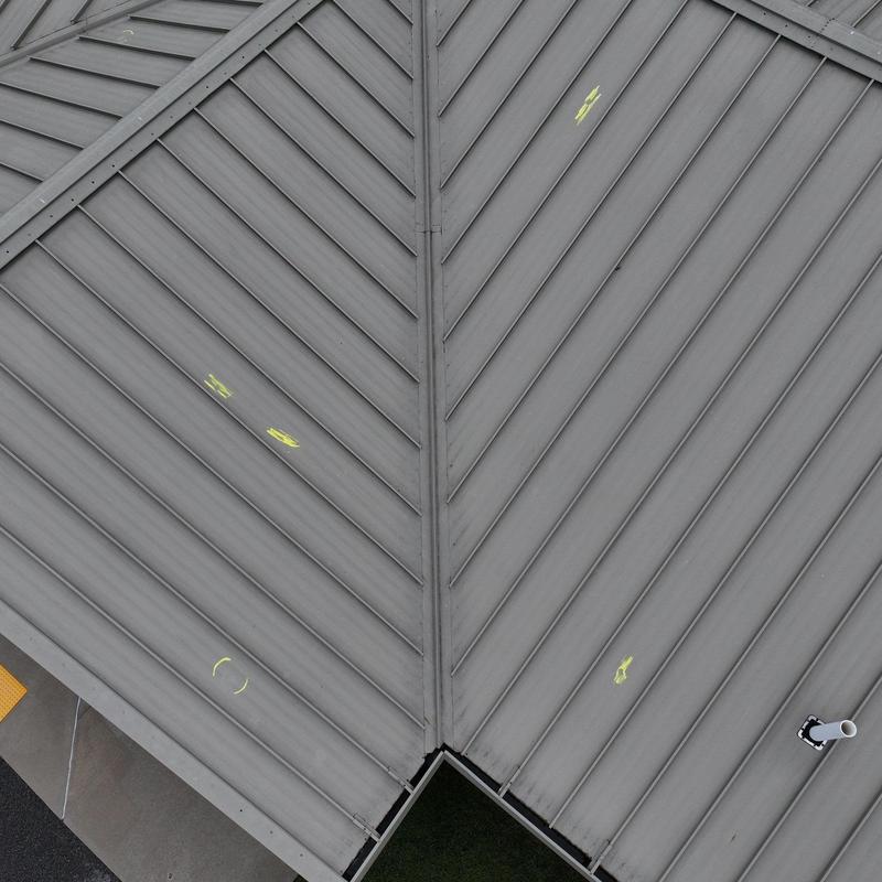Metal commercial roof with hail damage markings