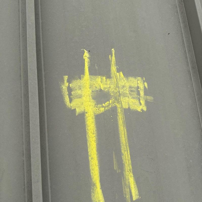 Metal commercial roof panel marked for hail damage repair