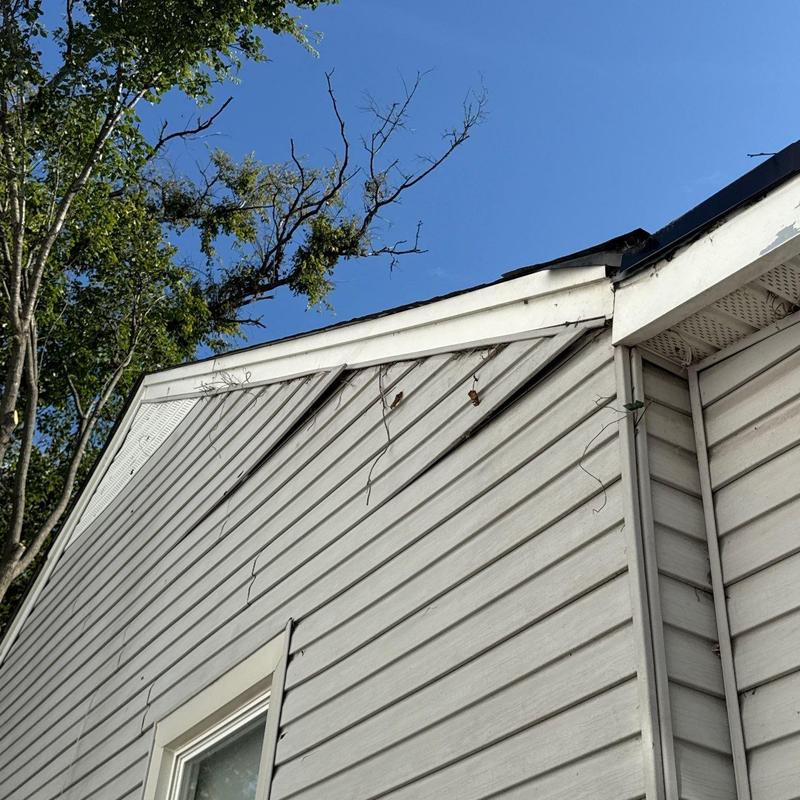Vinyl siding damage and loose nails on house exterior