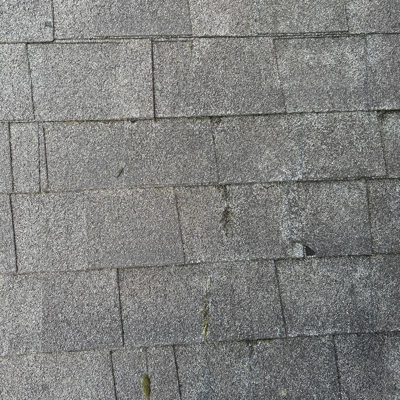 Asphalt shingles with hail damage on roof surface