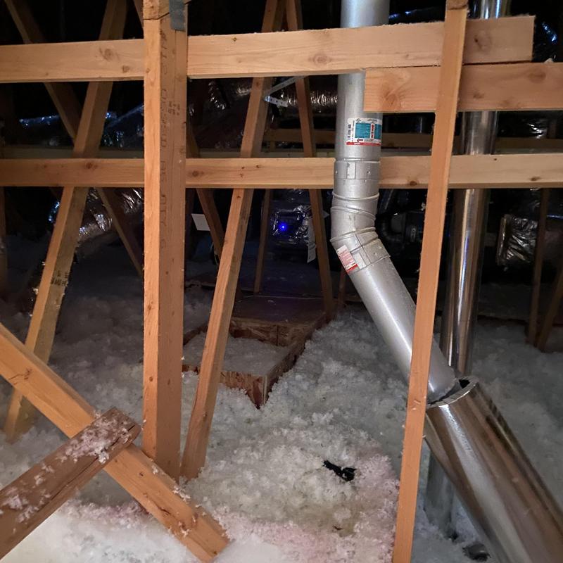 HVAC ductwork in attic with wooden framing