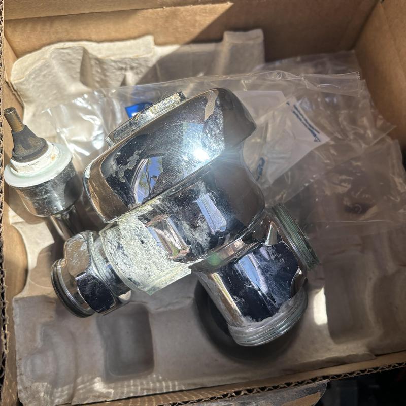 Men's urinal Sloan valve with corrosion buildup in box Men's urinal Sloan valve with corrosion buildup in box