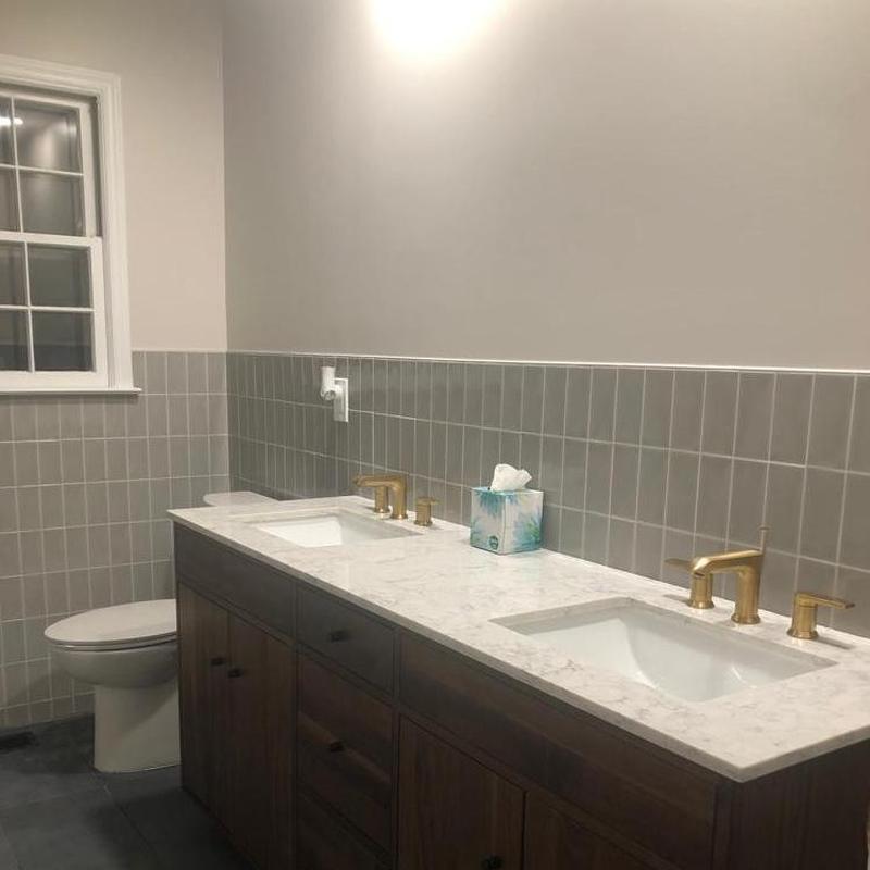 Double bathroom vanity with gold faucets and marble countertop