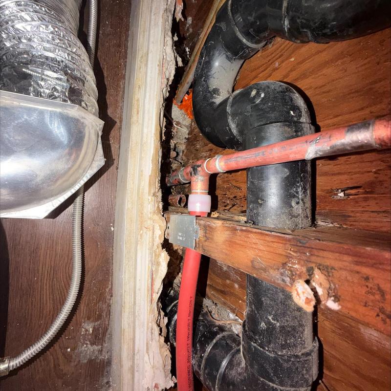 Copper and PEX-A pipes with vent and ductwork nearby