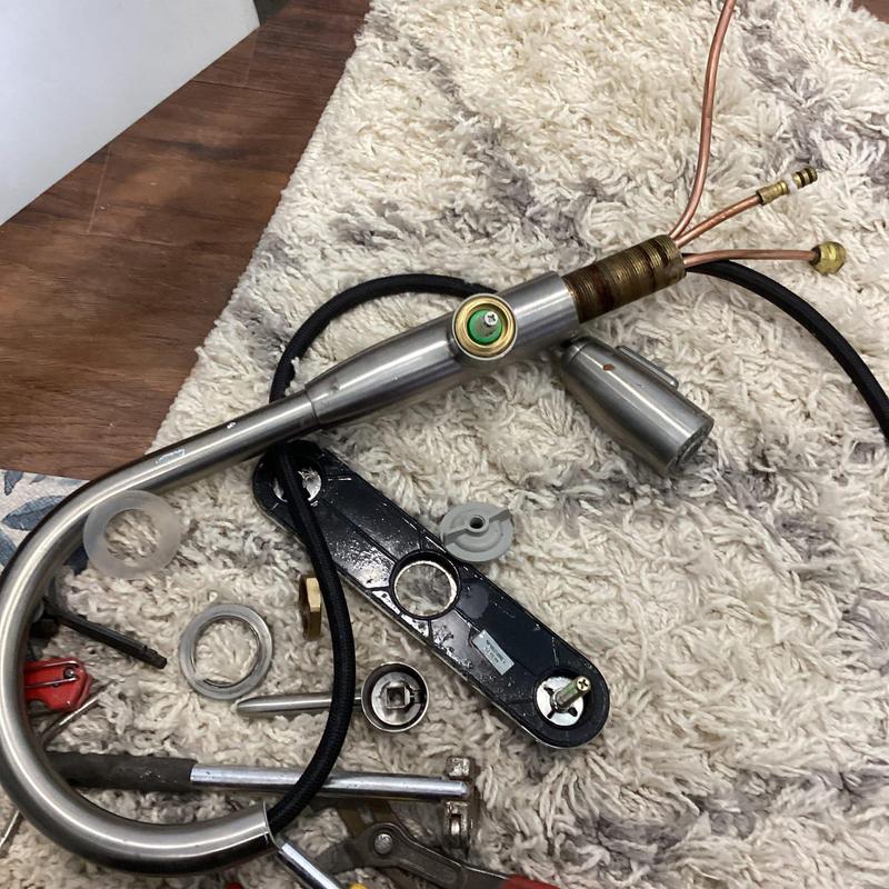 Kitchen faucet with hot water cartridge removed and leak parts