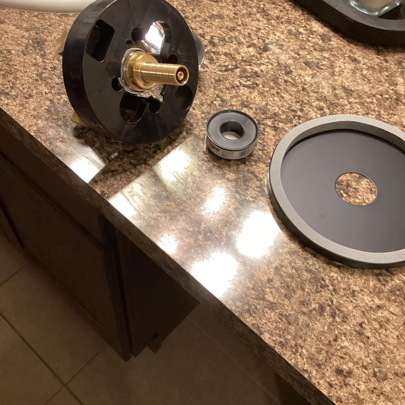 Shower valve parts and sealing tape on countertop