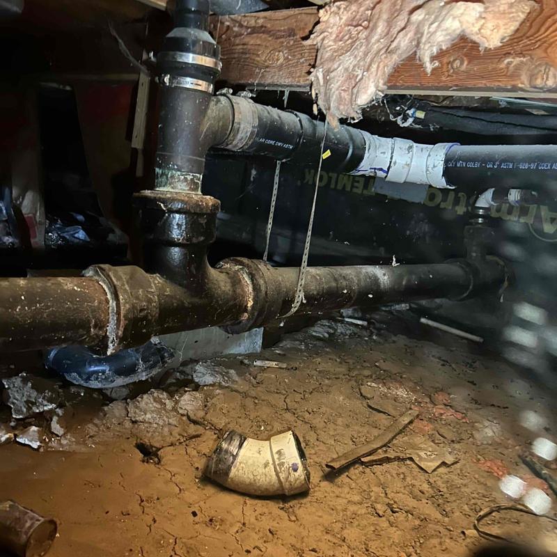 Mainline and crawl space plumbing with damaged pipe elbow