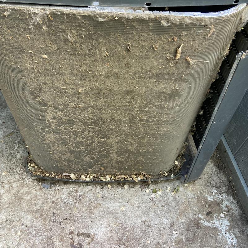 Outdoor air conditioner condenser coil clogged with debris