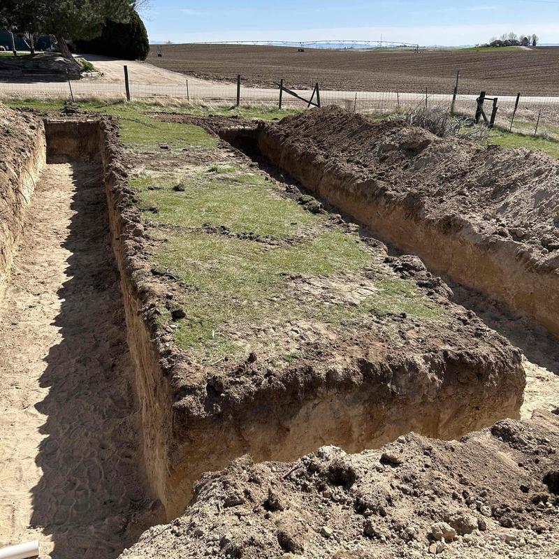 Septic tank excavation site with exposed soil trenches