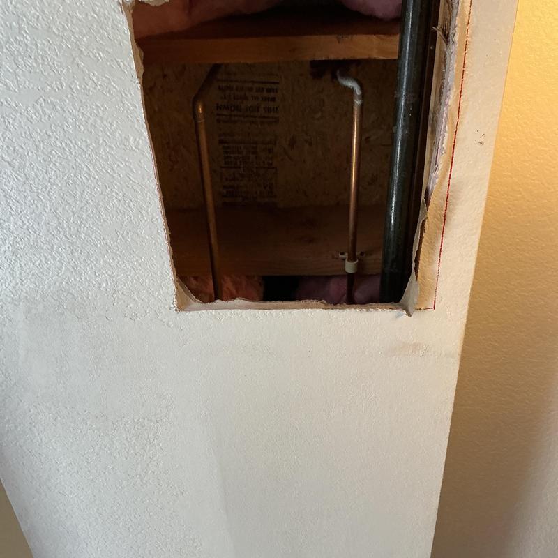 Shower arm access hole cut in drywall wall Shower arm access hole cut in drywall wall