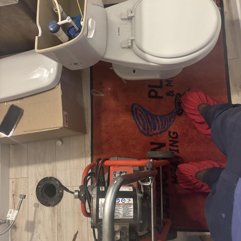 Toilet mainline with sewer machine unclogging in bathroom