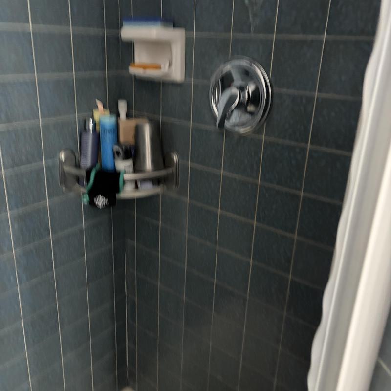Shower faucet and valve in blue tiled shower stall
