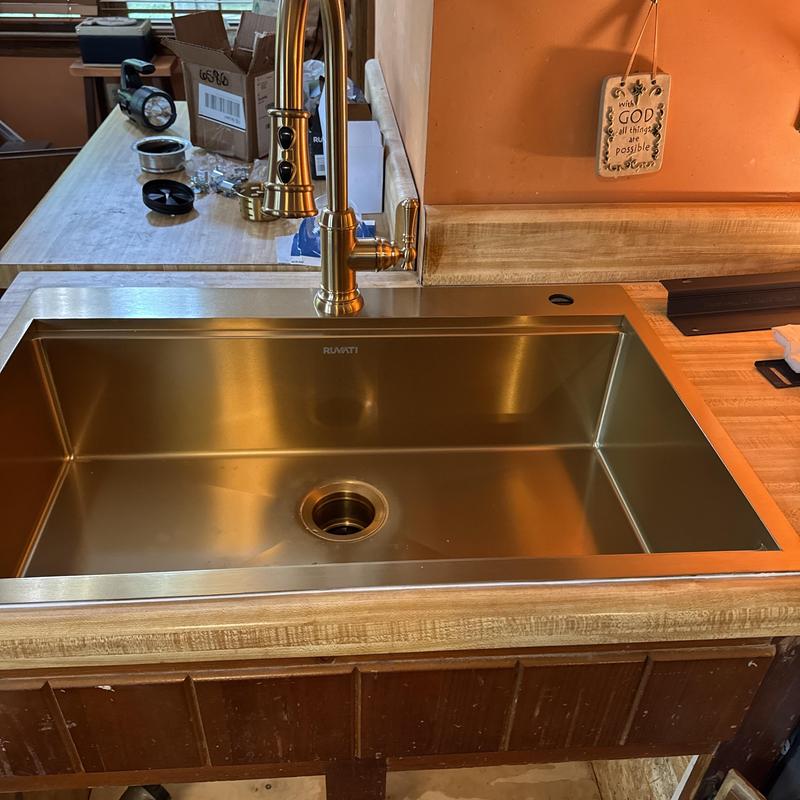Stainless steel kitchen sink with faucet installed