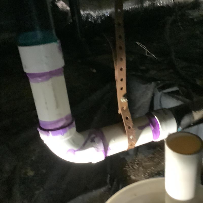 ABS kitchen drain line with purple primer in crawl space