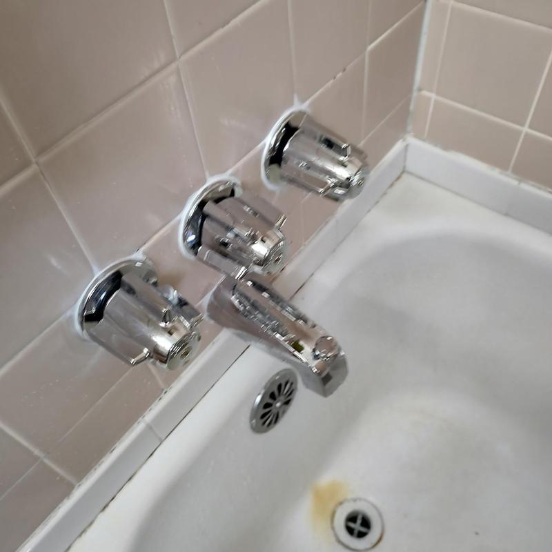Three-handle tub shower faucet installation in bathtub
