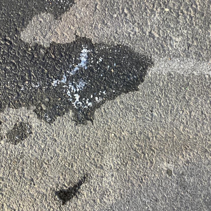 Water heater flush residue on asphalt surface