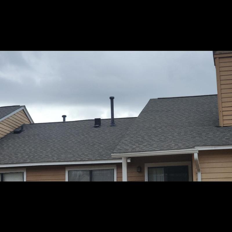 Apartment building asphalt shingle roof with vent pipes Apartment building asphalt shingle roof with vent pipes