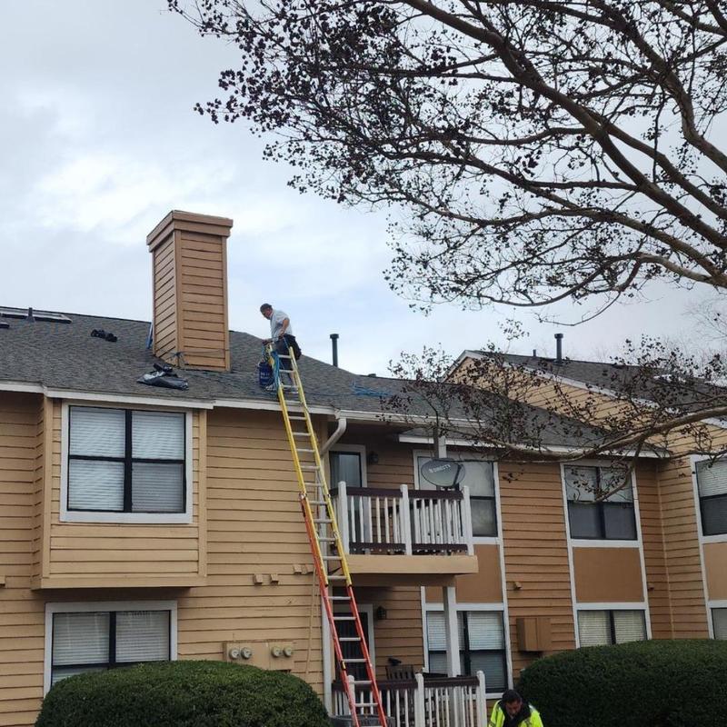 Apartment building roof with ladder and workers Apartment building roof with ladder and workers