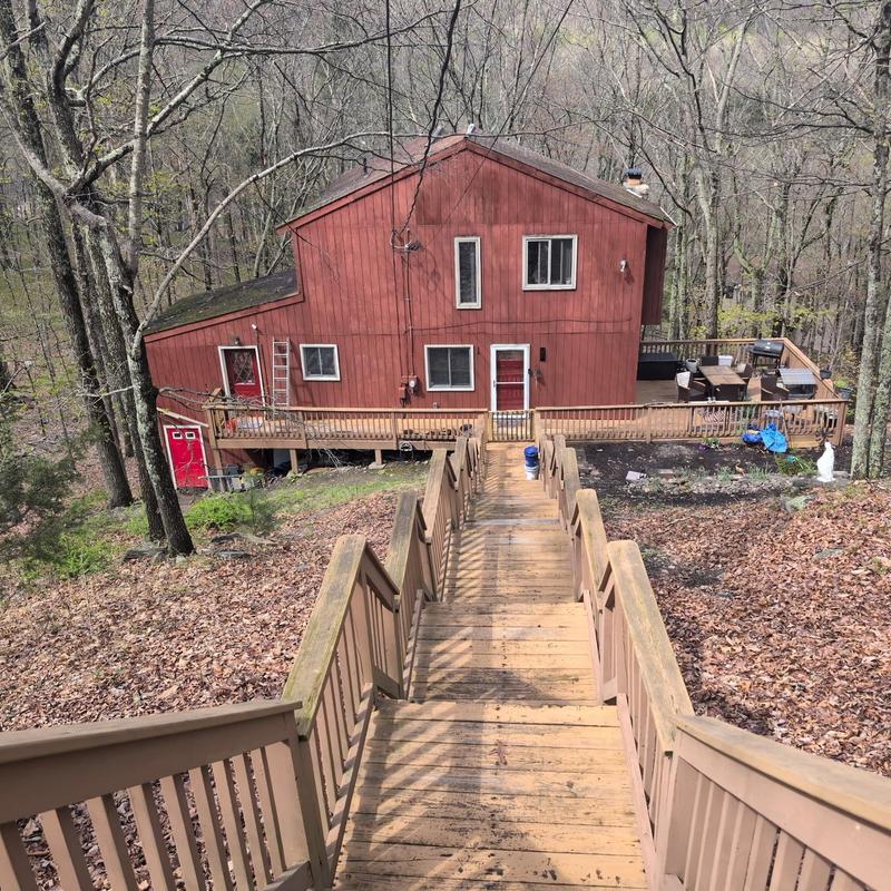 Wooden deck and railing leading to house exterior Wooden deck and railing leading to house exterior
