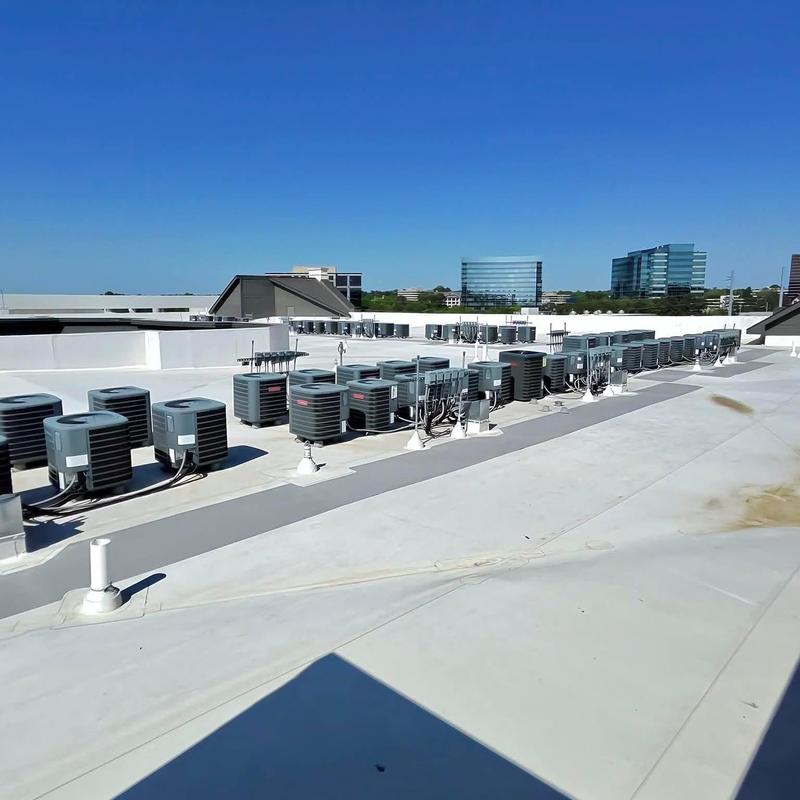Commercial rooftop HVAC units lined up on flat roof