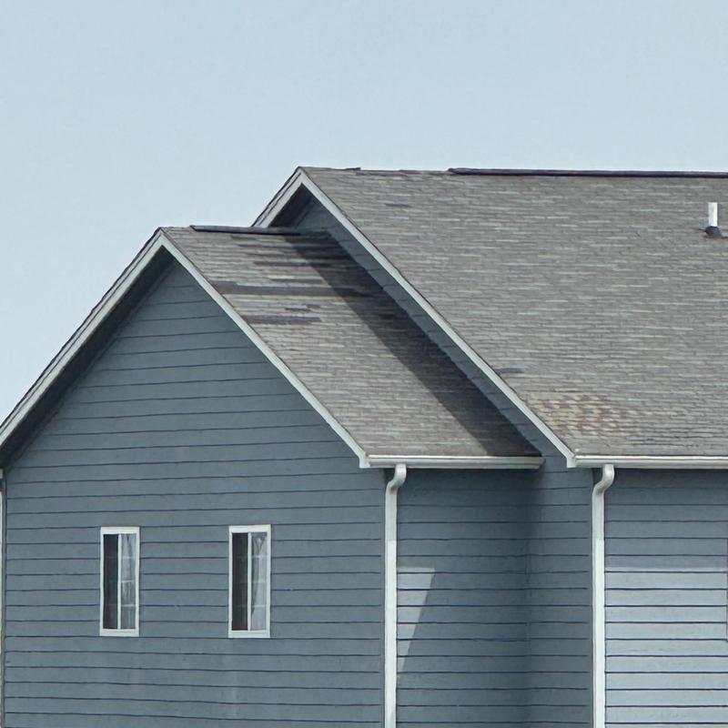 Asphalt shingle roof with storm damage on residential building