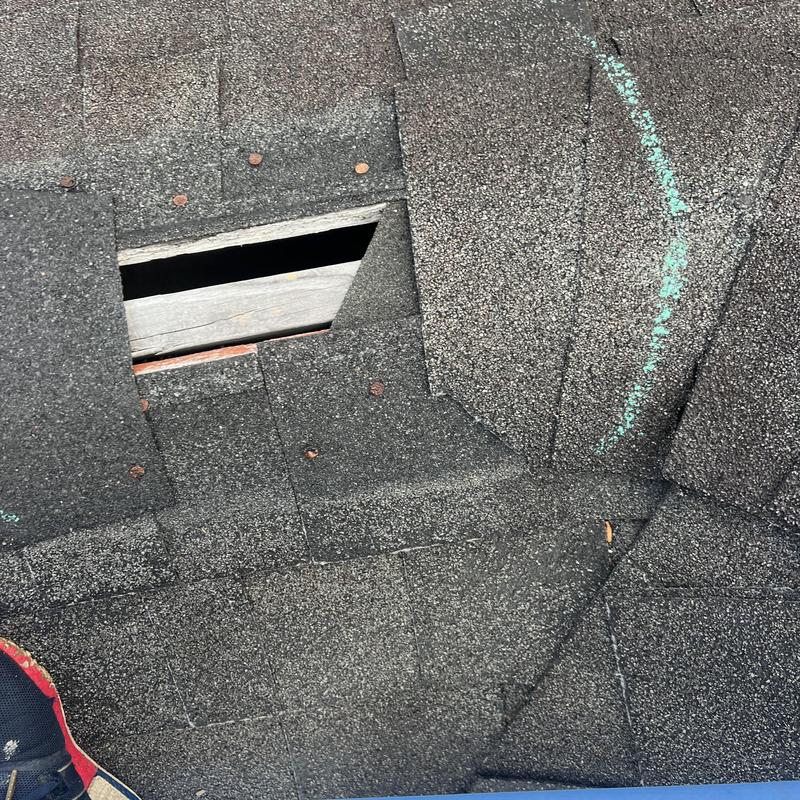 Asphalt shingle roof with missing shingles and damage
