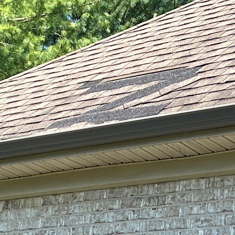 Asphalt shingle roof with visible hail damage patches