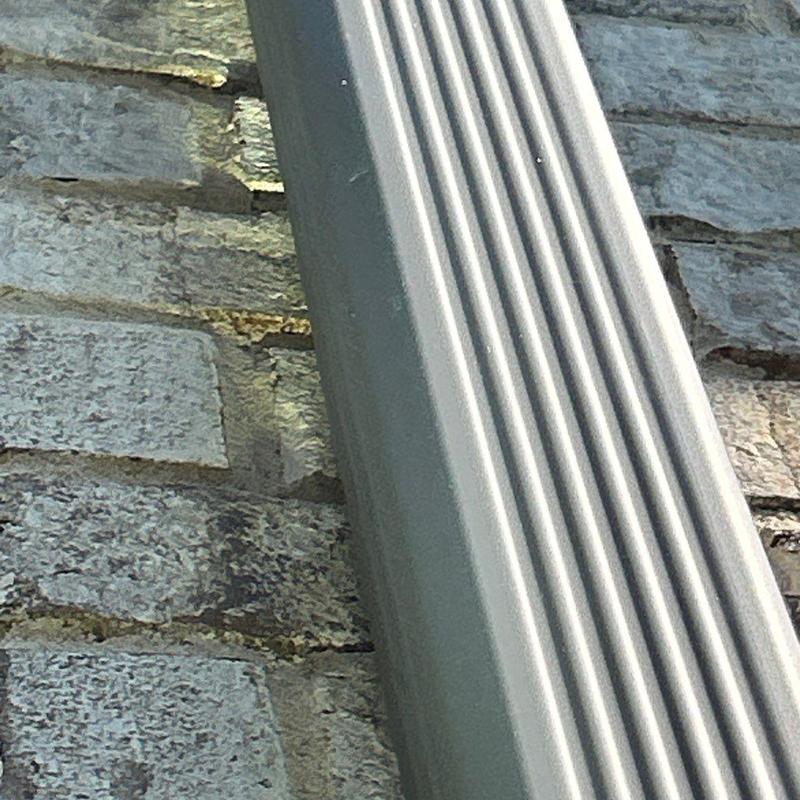 Metal downspout attached to brick wall detail
