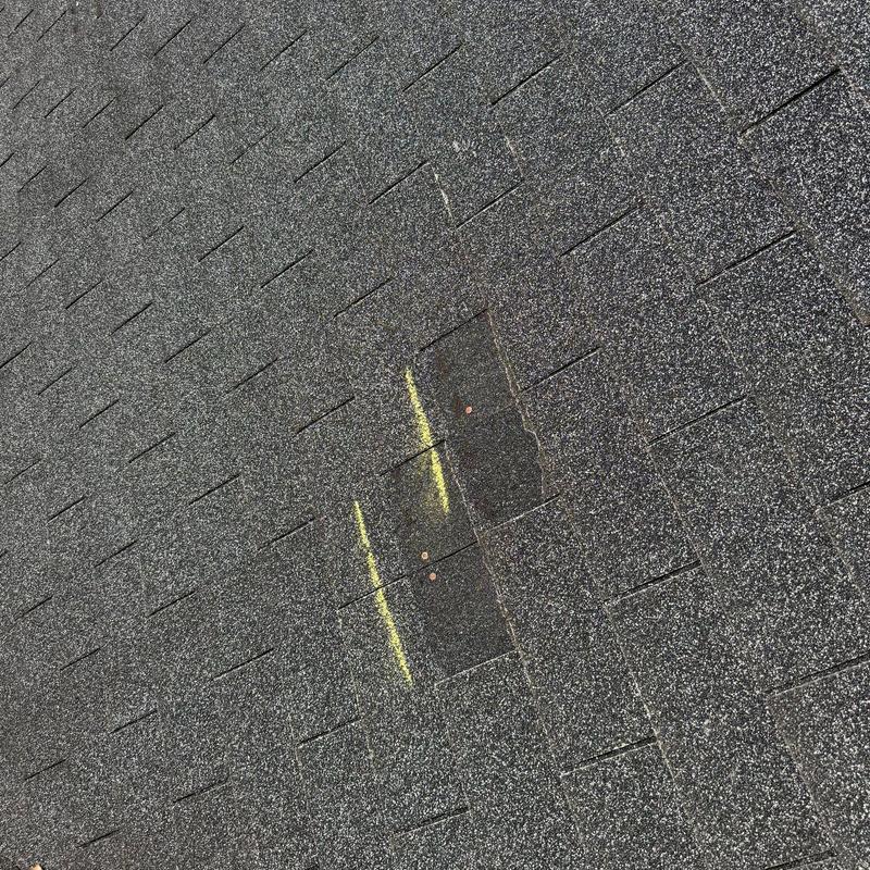 Asphalt shingle roof with marked hail damage