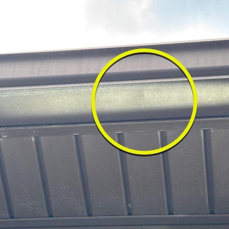 Metal gutter with dented area highlighted in yellow circle