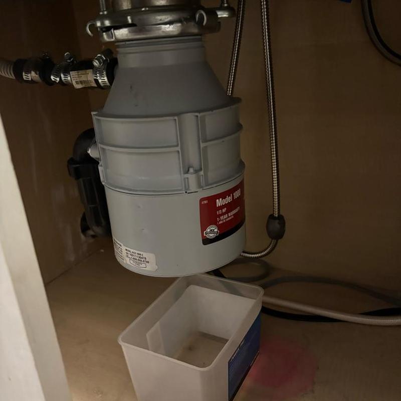 Garbage disposal under kitchen sink with drip tray