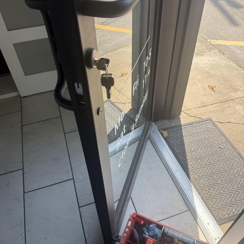 Storefront door lock with key during rekeying job Storefront door lock with key during rekeying job