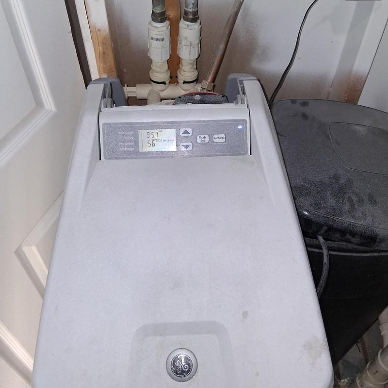 Water softener unit with control panel and plumbing connections