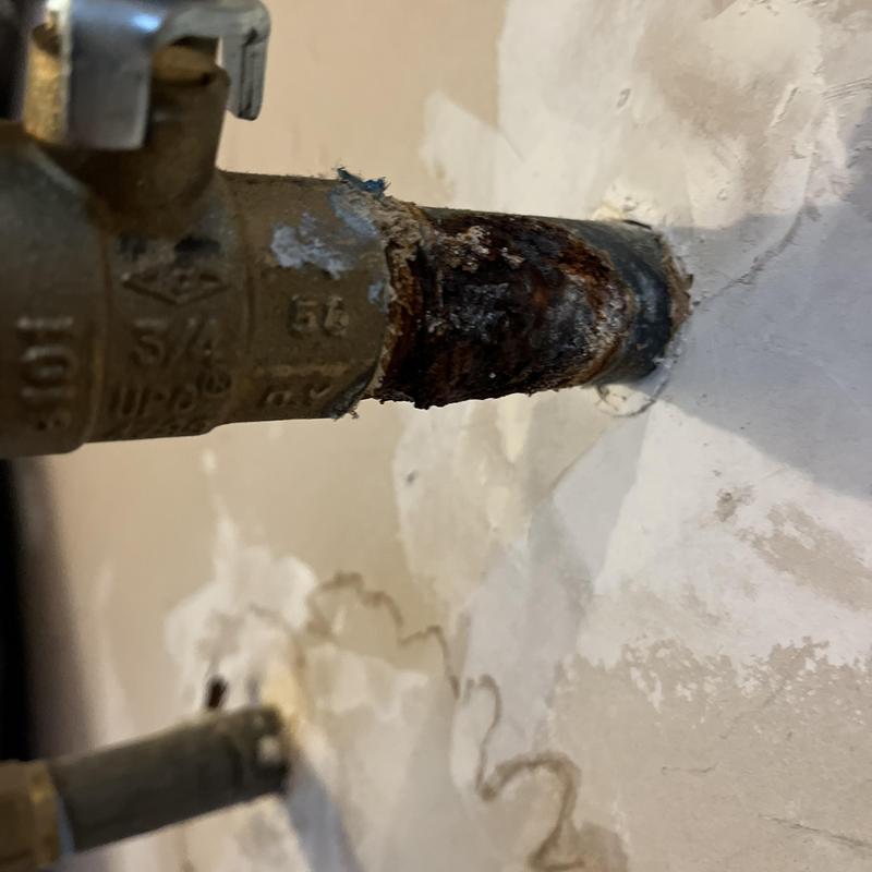 Corroded copper pipe with leaking valve fitting