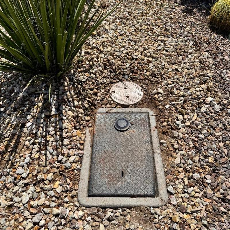 Water main access box with surrounding desert landscaping