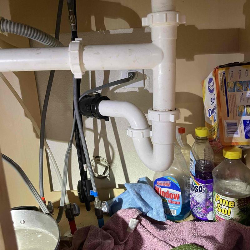 Garbage disposal and drain pipes under kitchen sink