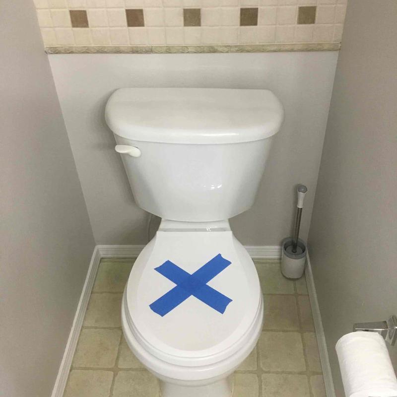 Toilet with blue tape on seat, master bathroom
