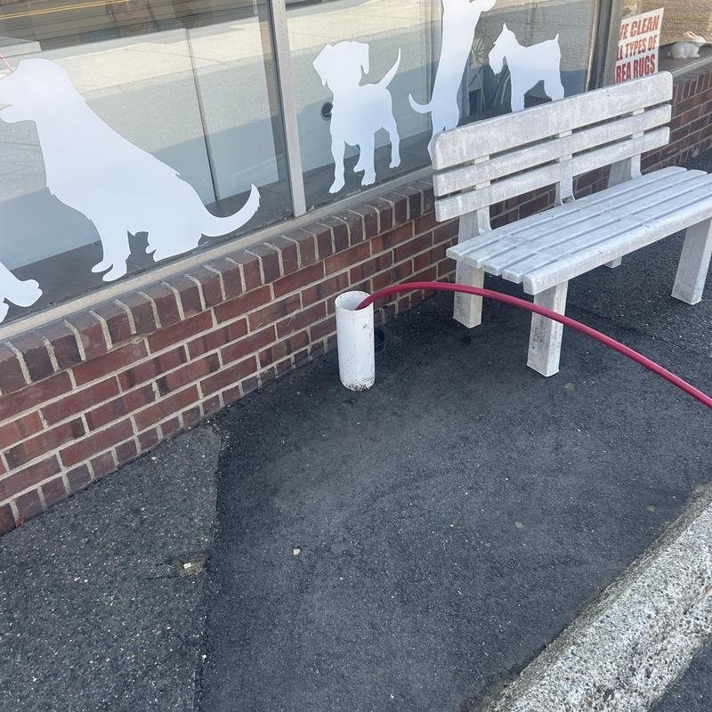 Drain cleanout hydro jetting with red hose near bench Drain cleanout hydro jetting with red hose near bench