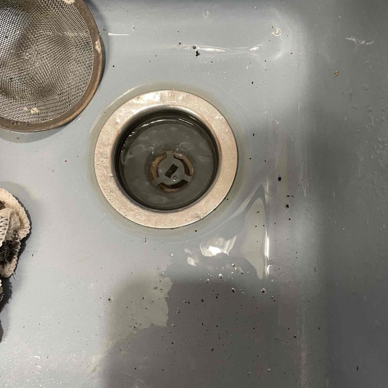 Kitchen sink drain with standing water and debris