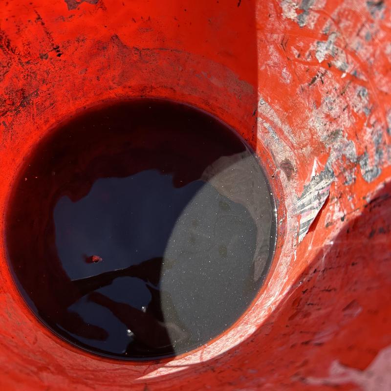 Drum trap removal with dirty water in orange bucket