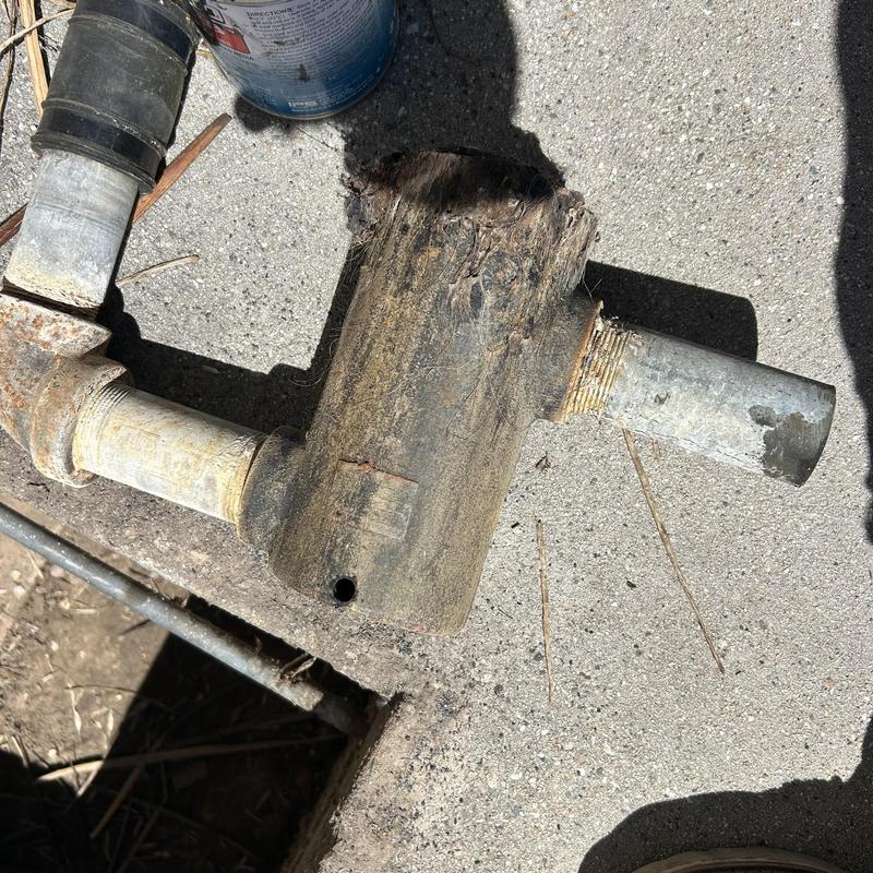 Drum trap plumbing pipe removed on concrete surface