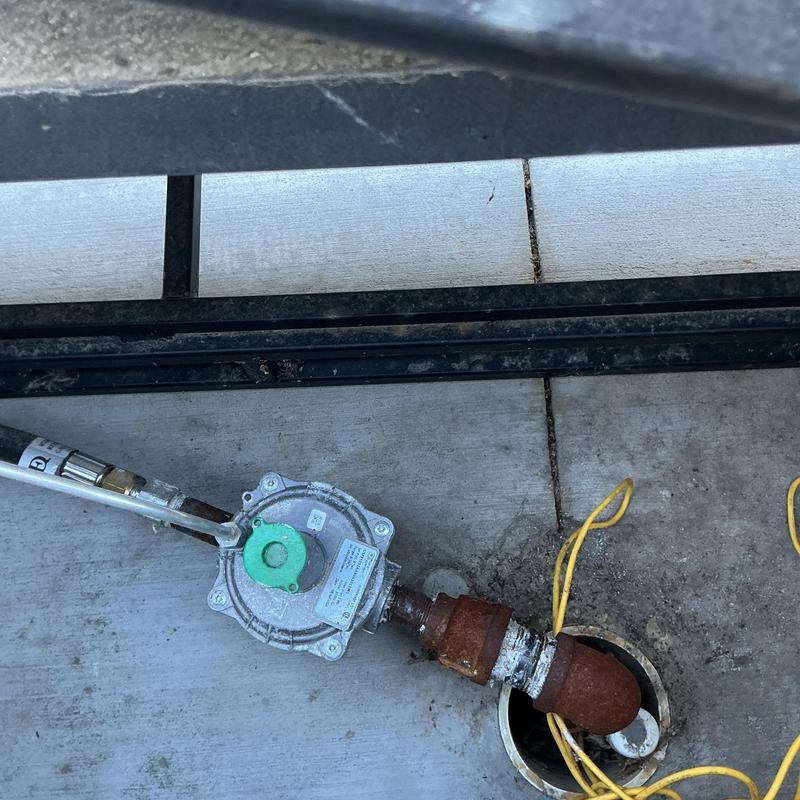 Gas regulator on pool heater piping outdoors