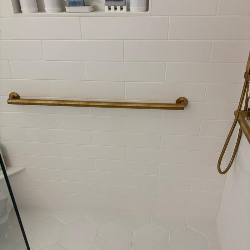 Kohler brass grab bar installed in master shower