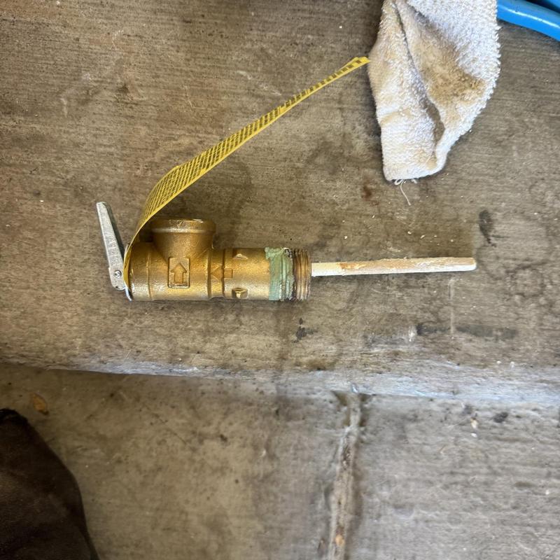 Water heater T&P relief valve with tag on floor Water heater T&P relief valve with tag on floor