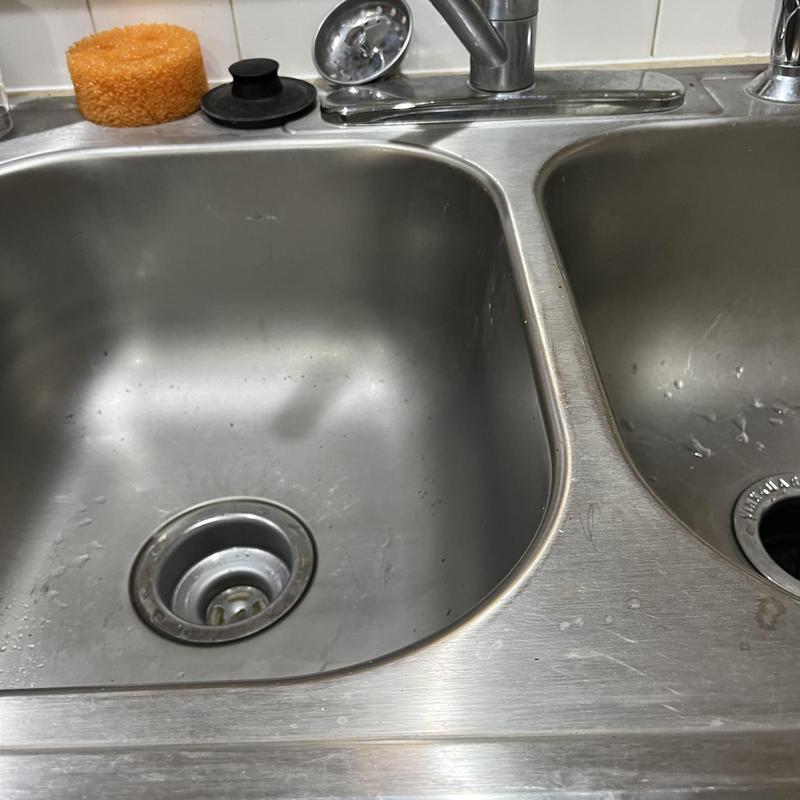 Kitchen sink drain and faucet with sponge on counter