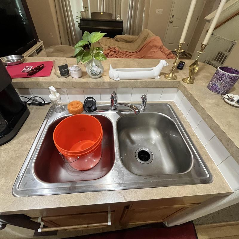 Kitchen sink with orange bucket in left basin